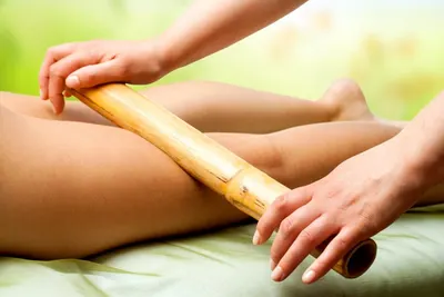 Bambuterapia: massagem com bastão de bambu na perna